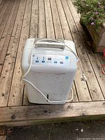 Front view of white GE dehumidifier showing air intake vent and control panel.