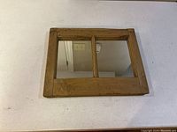 Front view of rustic farmhouse style mirror with two mirrored panels and wood frame
