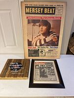 Full view of lot including Mersey Beat newspaper, framed The Sun article, and framed John Lennon quote
