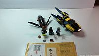 Blue and yellow starship, black spider-like flying vehicle, three mini-figures, some accessories and instruction sheet