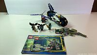 Complete and assembled Lego Chima crocodile set 70007 with minifigure, and a twin bike 70126 with its minifigures shown next to the instruction booklet.