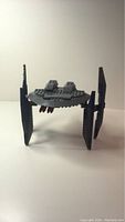 Dark gray Lego Hyena Droid Bomber model shown from front angle with vertical wings and central circular pod.