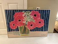 Front view of canvas painting showing pink flowers in vase with blue striped background and signature.