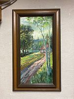 Frontal photo showing the entire framed oil painting with a landscape scene.