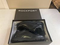Pair of black Rockport men's shoes in original box showing side and sole details, lace-up design, size 12