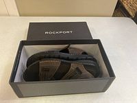 Rockport branded box open showing both brown and black Darwyn quarter strap sandals inside, size 11, brand new condition.