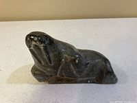 View of the walrus soapstone carving showing side profile and details of carving.