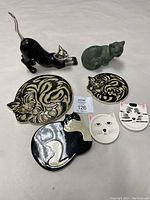 Lot arranged showing all items: two cat statues, two decorative cat-shaped coasters, and three cat face pottery tiles.