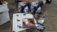 Two cat print pillows, stained glass-style cat lamp, cat-shaped handbag, book, and two fabric pot holders with cat themes