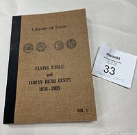 Front cover of the collector's book showing title, coin images, and volume number