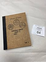 Full view of the Library of Coins storage book for Lincoln cents Part 2, Vol. 3, brown fabric cover with black binding.