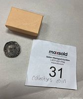 Coin beside small tan storage box and MaxSold lot tag #31