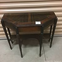 Front angled view of the antique wood entrance table showing inlaid veneer top and six turned legs.