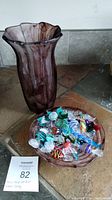 Photo of the marbled purple glass vase and matching glass candy dish filled with colorful glass candy pieces on tiled surface.