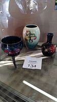 Overview of three Moorcroft pottery pieces: footed bowl, medium vase, small vase