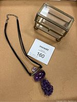 Amethyst necklace with three stones and glass trinket box on cardboard backing with lot number paper.