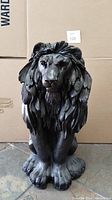 Front angled view of the black ceramic lion statue showing detailed mane and face.