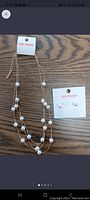 Photo of a three-tiered gold-tone necklace with spaced white pearls and matching white pearl stud earrings on Joe Fresh card.