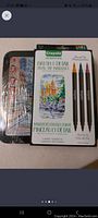 Crayola Brush & Detail Dual Tip Markers pack and metal tin possibly holding more art supplies