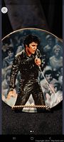 Front side of the commemorative plate showing Elvis Presley singing in black leather outfit.