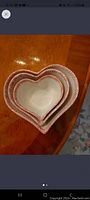 Nested view of three heart-shaped bowls showing the varying sizes and red decorative rim
