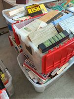 Four large plastic bins filled with a varied collection of books including religious, crafting, and self-help titles.
