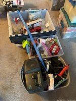 Boxes containing electronics: timers in plastic packages, red phone handset, flashlights, portable radio, and cables.