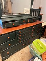 Large dresser with 12 drawers, three small drawers below mirror attached, dark finish with natural wood top and knobs