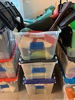 Three stacked plastic bins labeled 'BAGS,' filled with assorted handbags and totes.