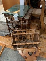 Three wooden nesting tables with glass tops, a wooden wall shelf with heart cut-out and pegs, and a wooden magazine holder with slatted design shown together.
