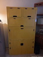 Yellow wooden storage unit closed showing all cabinet doors and overall form