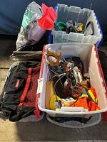 Overview of three bins with tools, gloves, saws, and tool bag