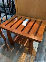 Front angle showing the wooden bench with slatted top and tapered legs