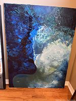 Full view of abstract painting showing side-profile face with blue and white tones on stretched canvas.
