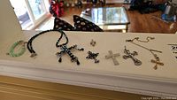 Full view of all jewelry items laid out showing crosses on necklaces and bracelet
