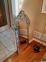 Full view of the rectangular vintage etched mirror showing floral designs and decorative top.