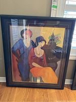 Full view of the framed Tarkay print leaning against a wall, showing the overall piece including frame and matting.