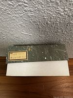 Top view of a green marble patterned box lid with Japanese labeling and sticker.