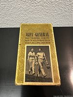 Original yellow textured box with black text and black and white photo of two people walking. Text on box reads 'AGFA GENERAL F6.3 FOLDING CAMERA TAKES PICTURES THIS SIZE 2 1/4 x 3 1/4 INCHES'.