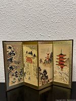 Front view of the 4-panel folding screen showing detailed painted Asian pagodas and winter scenery.