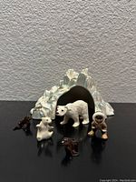 Front view of all figures arranged inside and in front of the ceramic iceberg, showing details of each figure.