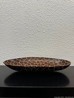 Side angle photo showing the oval shape and giraffe print detail of the bowl