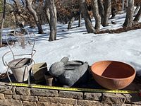 Photo of the 5 outdoor planters arranged on a stone ledge covered with snow background, showing sizes with tape measure.