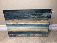 Front view of abstract painting showing layered horizontal paint strokes in blue, beige, white, and gold.