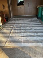 Rectangular striped rug laid out in a garage setting, showing full dimensions and overall appearance.