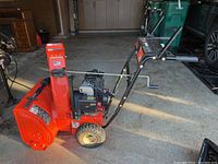 Side view showing red housing, engine and tires