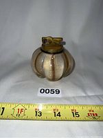 Front view of round white Murano lighter with gold flecks and copper aventurine stripes, showing brass lighter insert on top