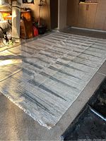 Full view of large woven rug showing pattern, texture, and size in surrounding environment