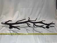 Full view of bronze branch-shaped coat/towel rack with tape measure showing length of approximately 22 inches.