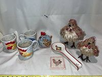 Seven-piece lot of chicken-themed kitchen items including mugs, figurines, spoon rest, coaster, and lidded bowl.